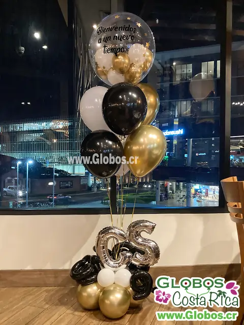 Arreglo de globos dorados, negros y blancos con mensaje de bienvenida a un nuevo tiempo.