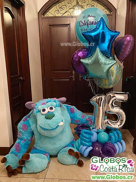 Decoración de cumpleaños de 15 años con globos y peluche azul grande, inspirado en una temática especial.