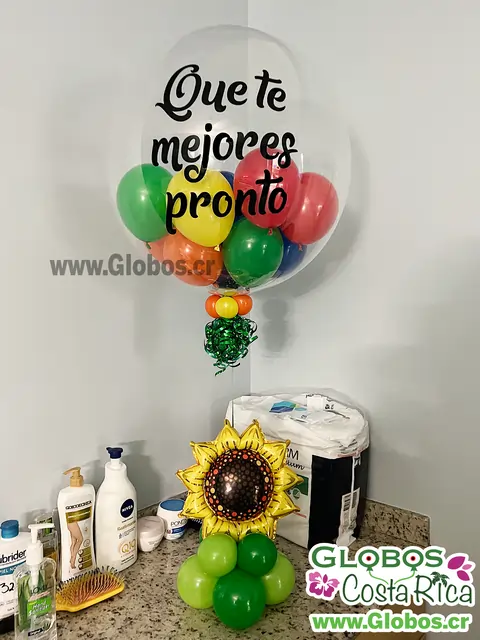 Arreglo de globos con mensaje "Que te mejores pronto" y un globo en forma de girasol en la base.