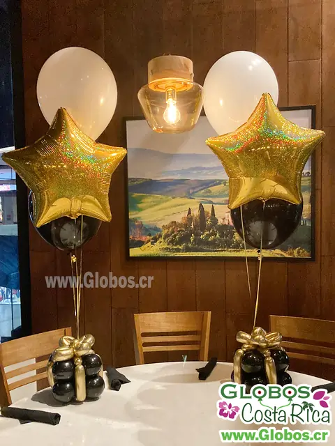 Arreglo de globos dorados y negros, creando un ambiente festivo con una brillante estrella.