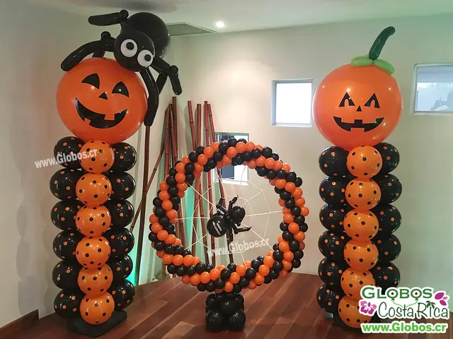 Decoración de Halloween con globos de calabazas, araña y telaraña, ideal para fiestas temáticas.