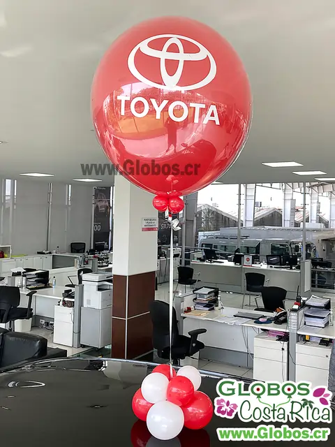 Globo decorativo de Toyota en color rojo con logo, ubicado en una concesionaria de autos.