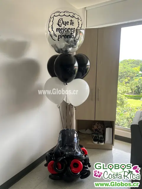 Arreglo de globos en blanco y negro con mensaje de "Que te mejores pronto" y una figura de Darth Vader para desear pronta recuperación.