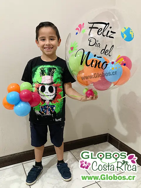 Niño sonriendo con globo decorado para celebrar el Día del Niño.