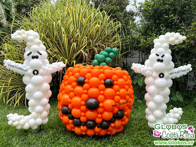 Decoración de Halloween con figuras de calabaza y fantasmas hechos con globos de colores naranja, blanco y negro.