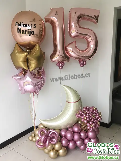 Decoración de globos rosados y dorados con temática de luna y estrellas para un 15 años.