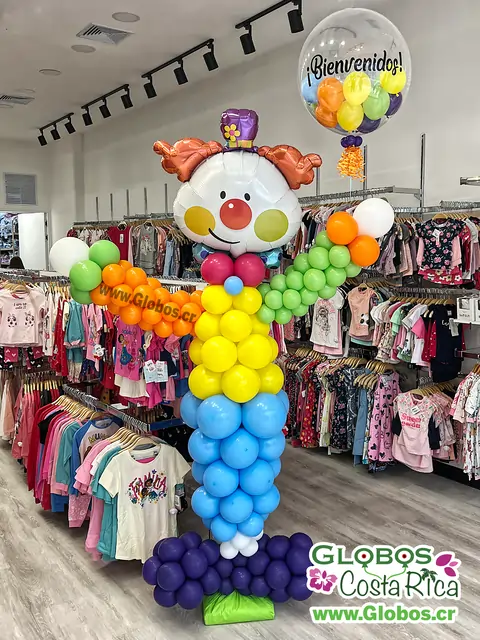 Arreglo de globos de payaso con mensaje de bienvenida para alegrar la entrada de una tienda.